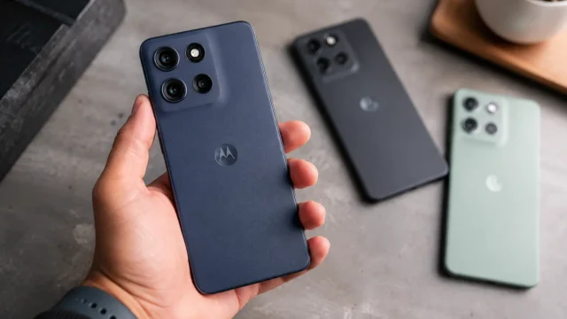 Mão segura celular Motorola 256GB em primeiro plano com outros modelos ao fundo